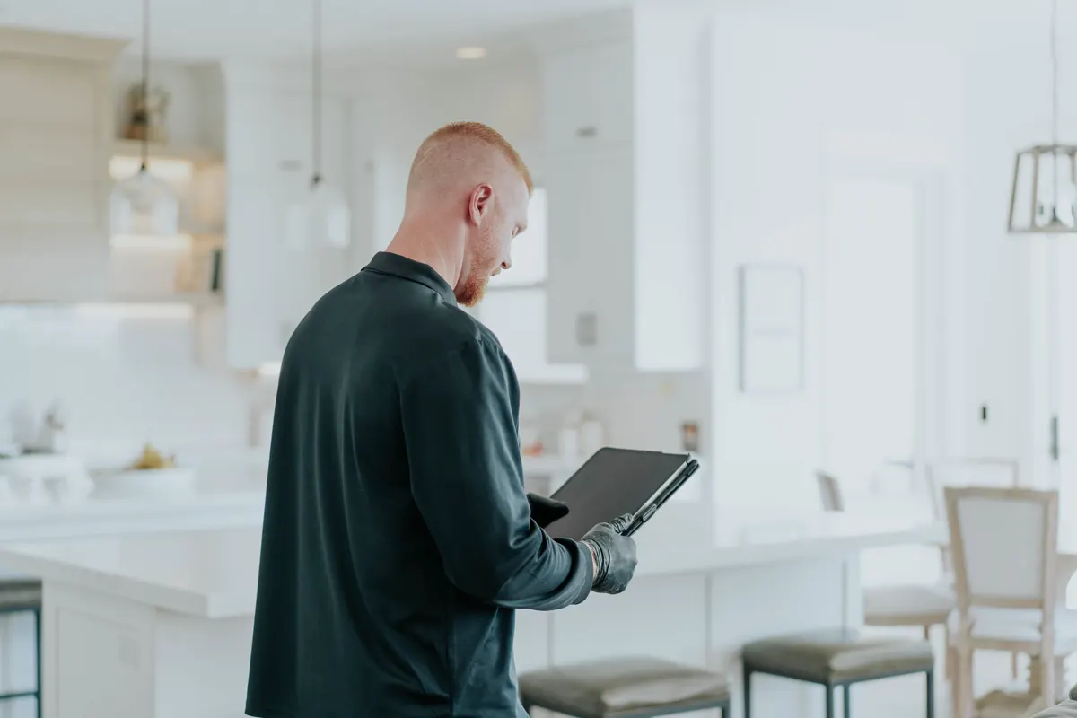Technician documenting an odor inspection on a tablet in a kitchen